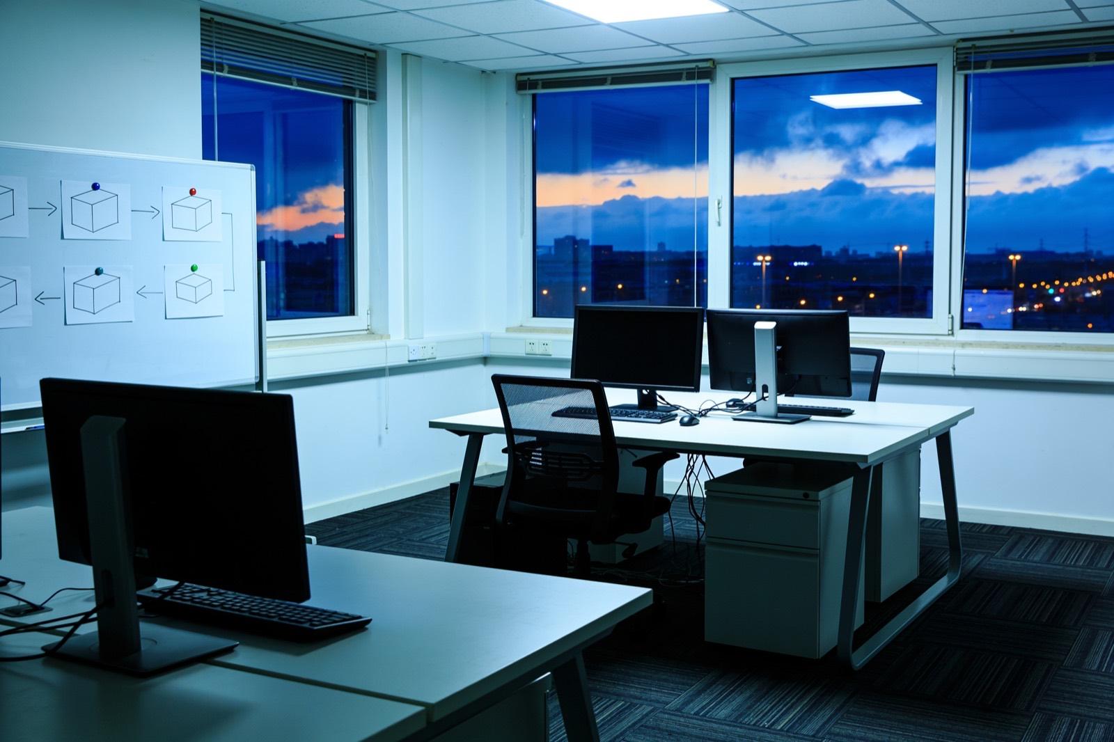 Illustrative: a software team's open office with monitors showing dashboards